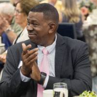 Gentleman clapping while listening to speaker